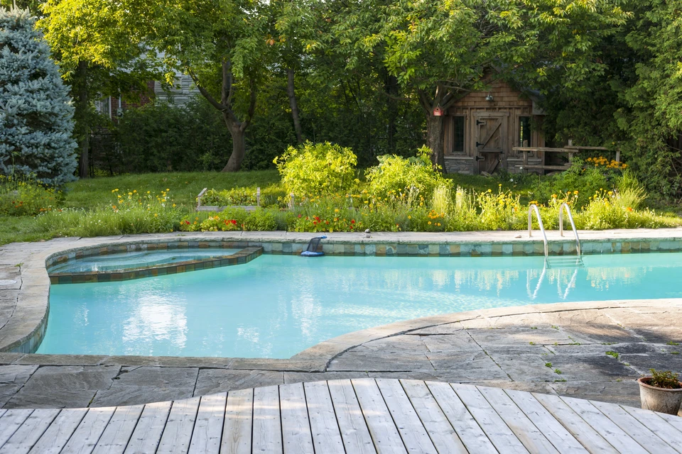Piscine extérieure avec spa intégré dans jardin paysager résidentiel