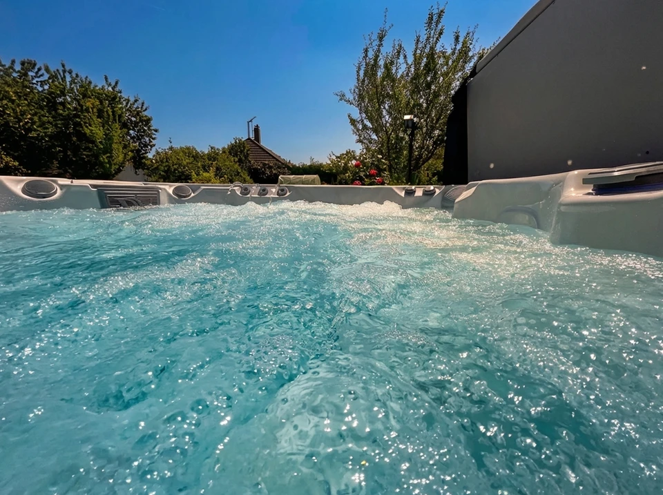 Photographie d'une équipe de 2-3 professionnels (hommes et femmes) dans le showroom de Temple Wellness, discutant autour d'une maquette ou d'un affichage de piscine/spa. Les professionnels portent une tenue professionnelle décontractée (polo ou shirt avec logo de l'entreprise de préférence), souriants et engagés dans une conversation consultative. En arrière-plan, on aperçoit des équipements de bien-être aquatique (spa visible, ou détails de bassin). L'atmosphère doit être professionnelle, moderne et inspirante, reflétant l'expertise et la passion pour l'innovation en bien-être aquatique.